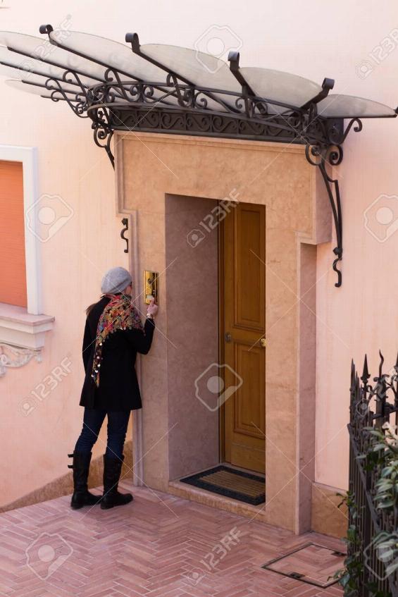 woman ringing doorbell at a house